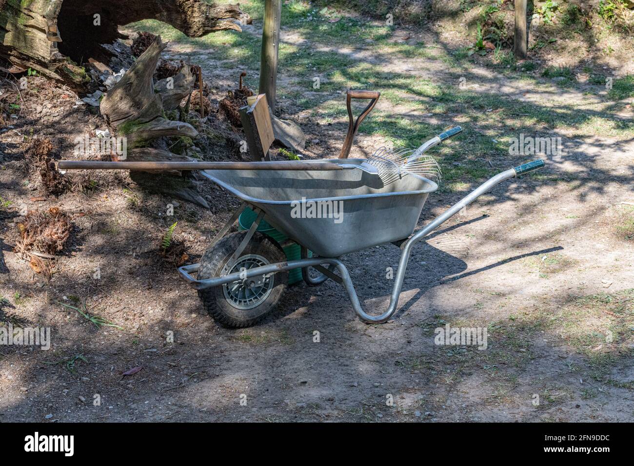 wheel barrow loaded with tools in a shady place Stock Photo