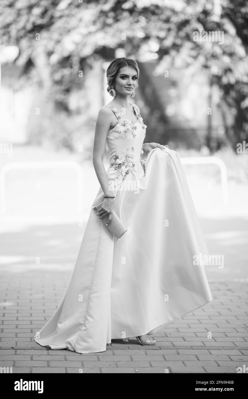 Grayscale of a gorgeous Caucasian blonde female holding her elegant yellow dress in the street Stock Photo - Alamy Grayscale of a gorgeous Caucasian blonde female holding her elegant yellow dress in the street Stock Photo - Alamy