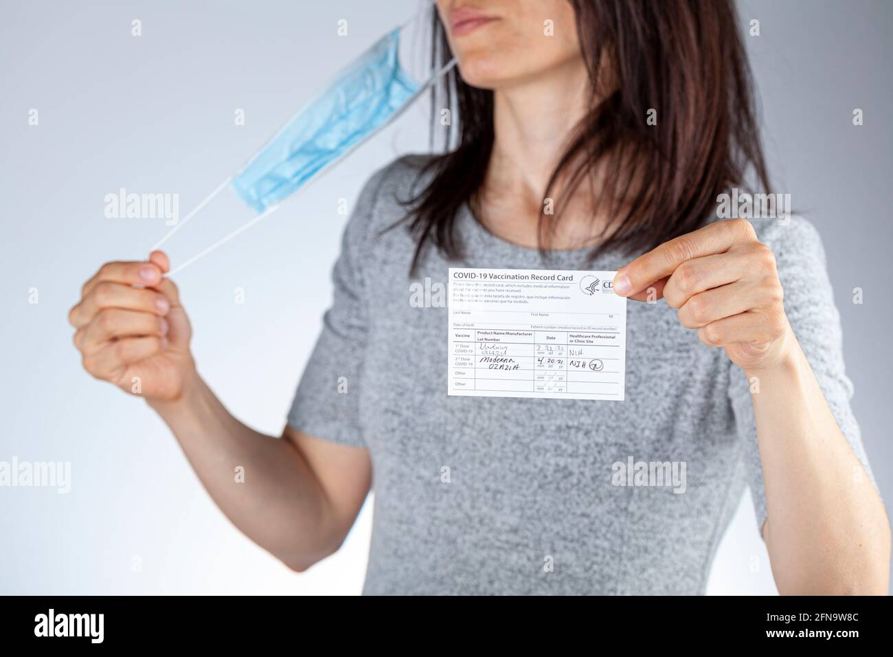 Clarksburg, MD, USA 05-16-2021: CDC announced the lifting of face mask requirement for fully vaccinated individuals. A woman showing vaccination recor Stock Photo