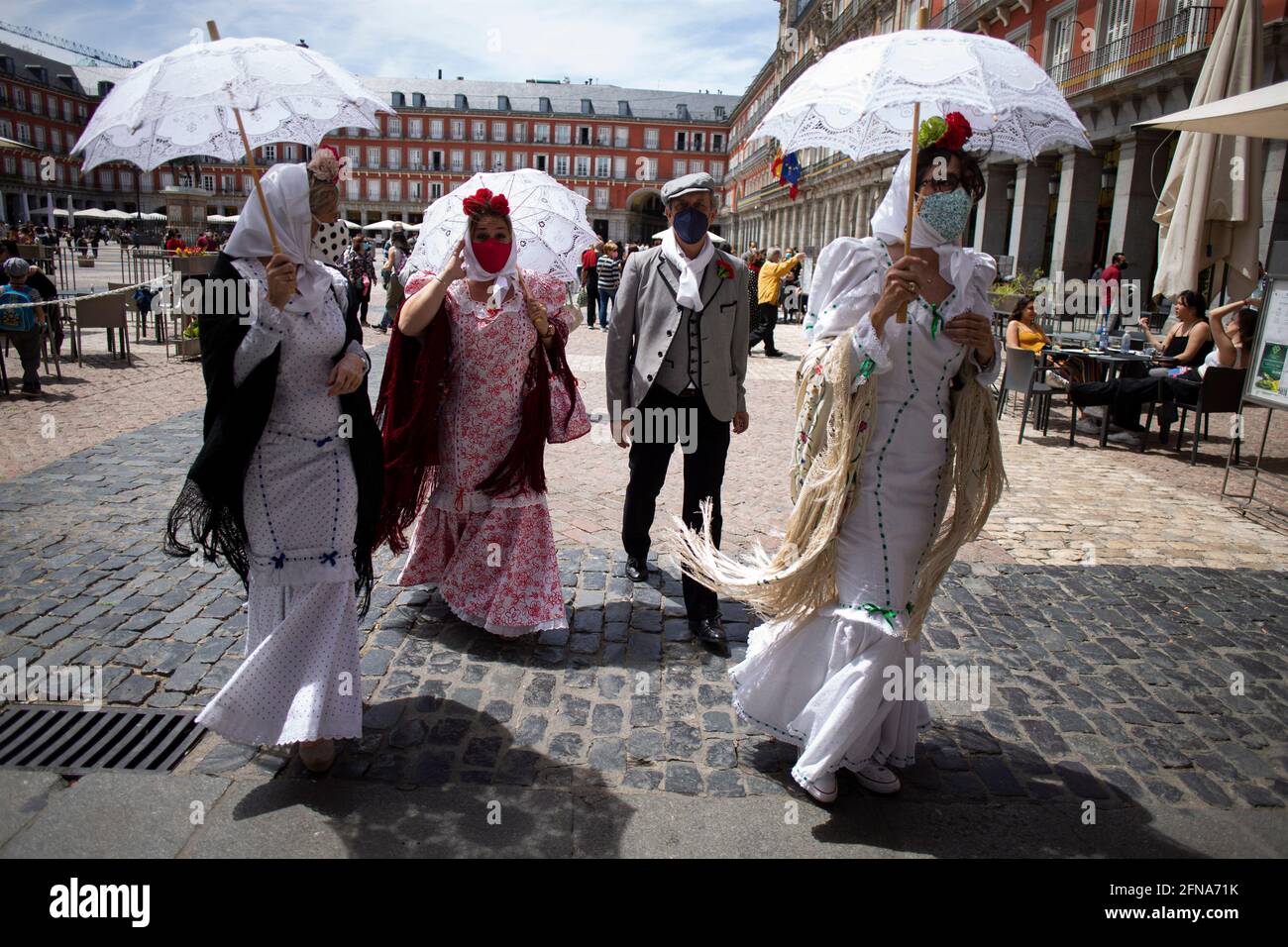 Madrid, Spain. 15th May, 2021. A group of friends dressed in traditional "Chulapo" and "Chulapa" costumes walk through the Plaza Mayor in Madrid during the celebrations of the day of the patron saint of Madrid, San Isidro Labrador. Credit: SOPA Images Limited/Alamy Live News Stock Photo