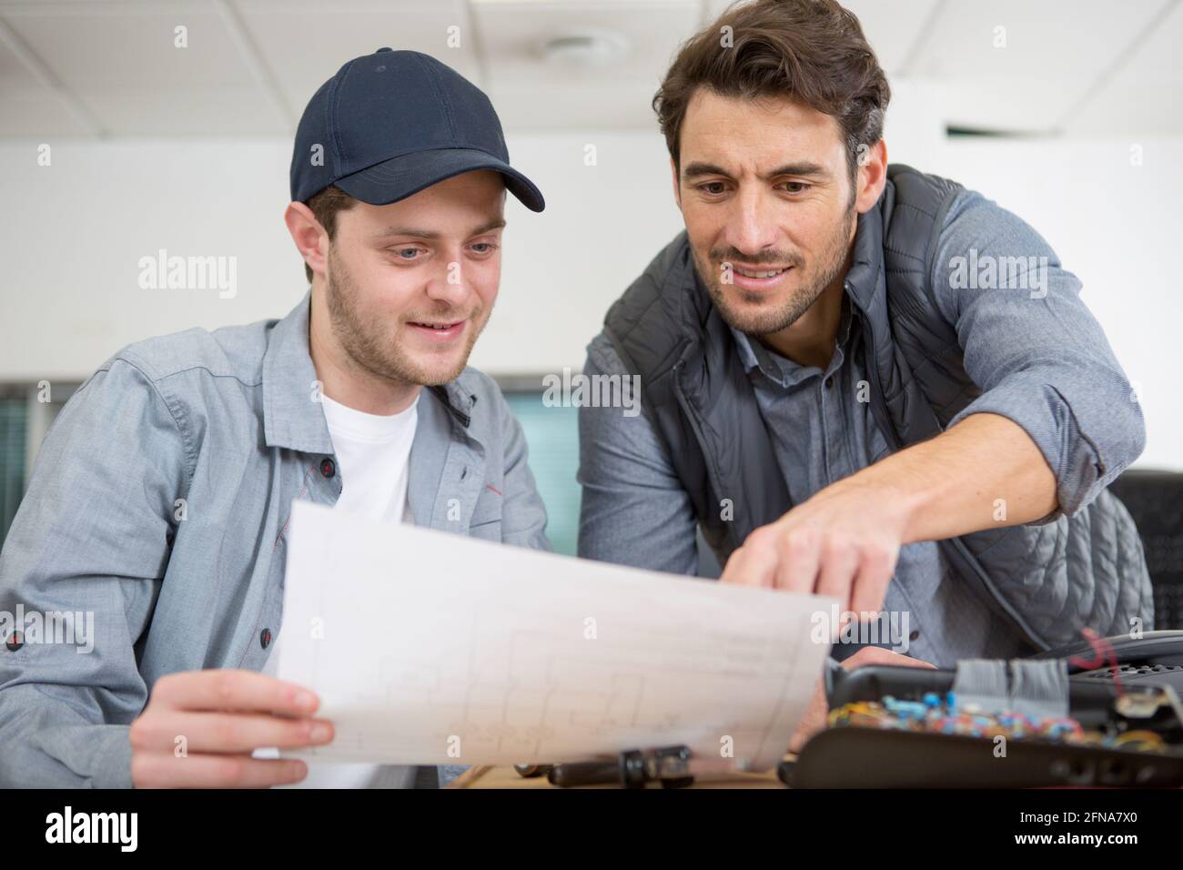 man working with apprentice in printing house Stock Photo