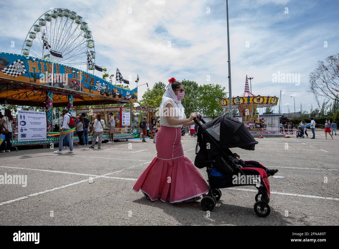 Madrid, Spain. 15th May, 2021. A woman pushing a baby stroller dressed as a chulapa seen during the San Isidro festivity in the IFEMA fairground.One of the most celebrated holidays of Madrid is the Feast Day of San Isidro which this year took place in the IFEMA fairground. Credit: SOPA Images Limited/Alamy Live News Stock Photo