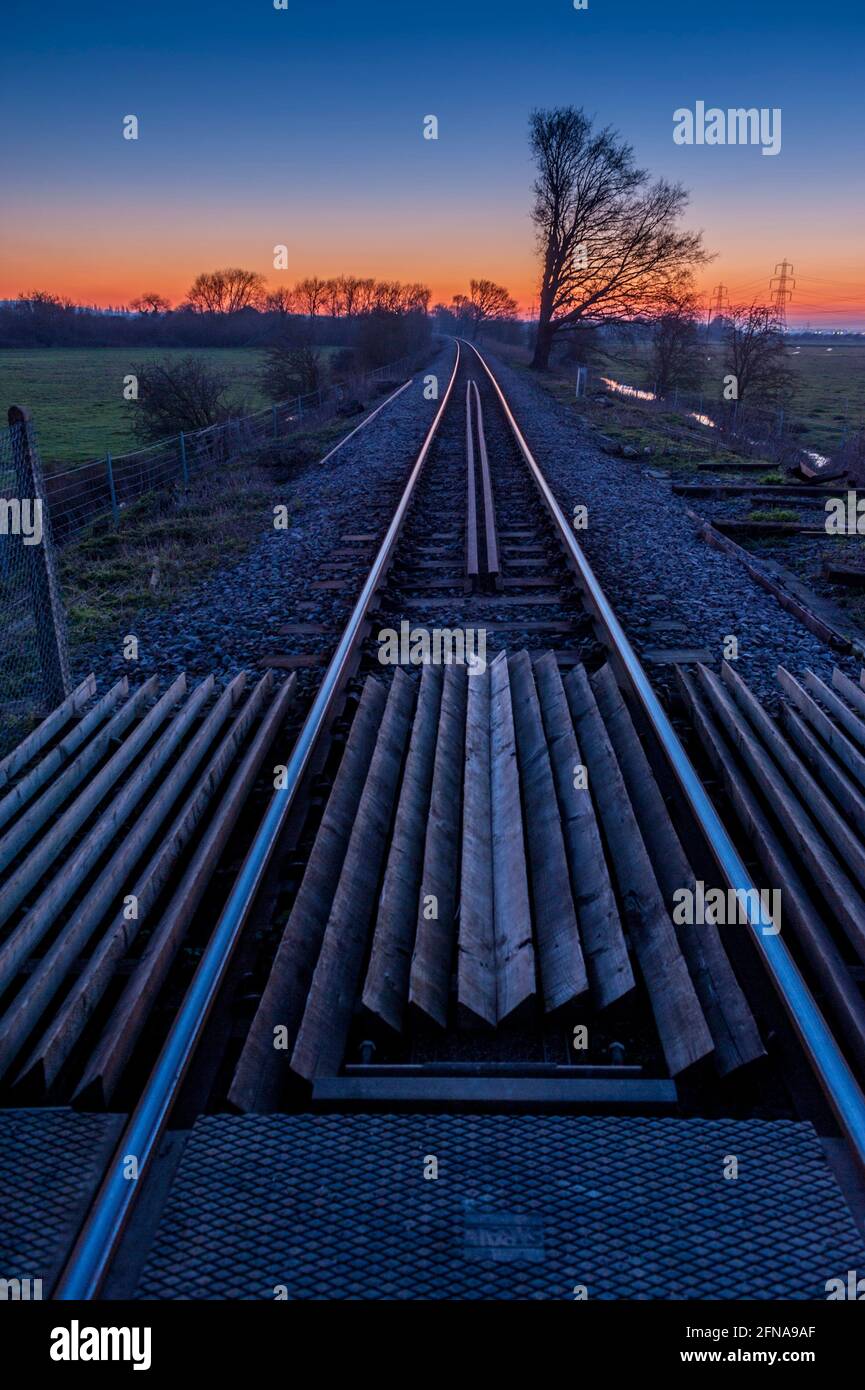 Railway lines at sunset on the Thames marshes at Lower Higham Kent with
