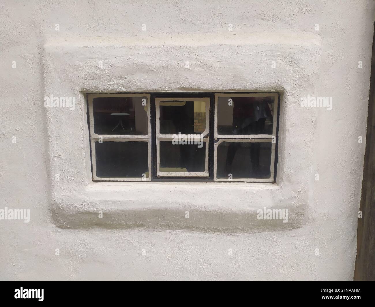 Horizontal rectangle window in a whitewashed wall with the reflection