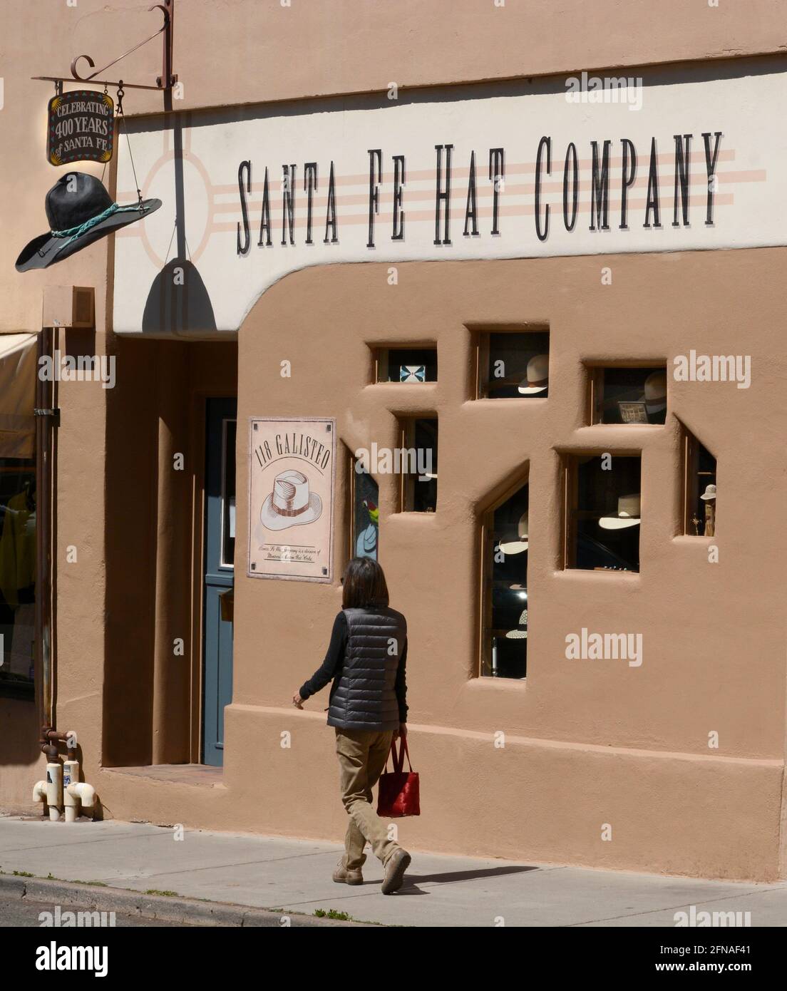 A woman walks past the Santa Fe Hat Company retail store in Santa Fe