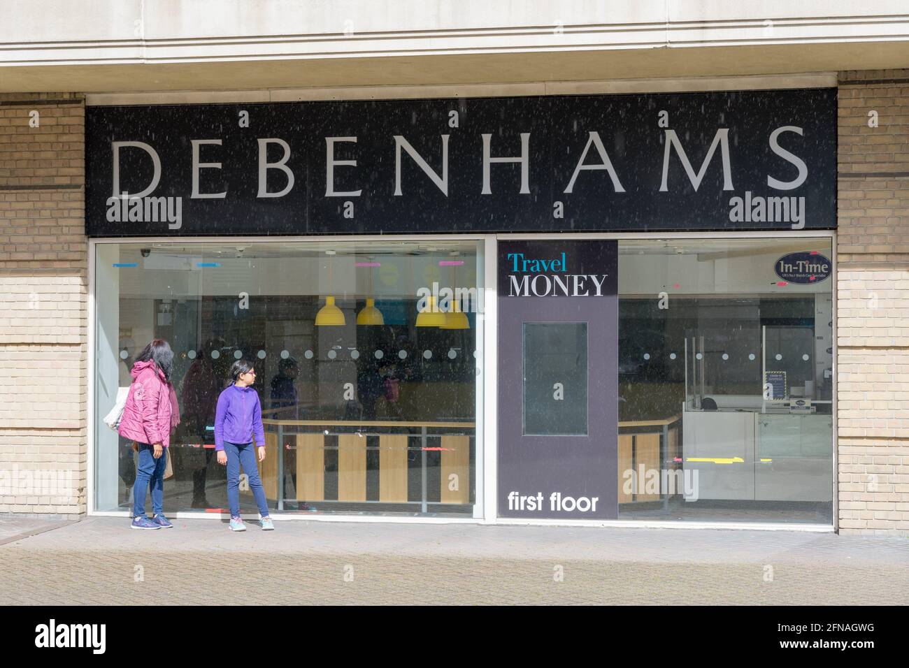 mother and daughter look throught shop window into empty  Debenhams store closed for good on 15th May 2021, Bromley, Kent, England Stock Photo