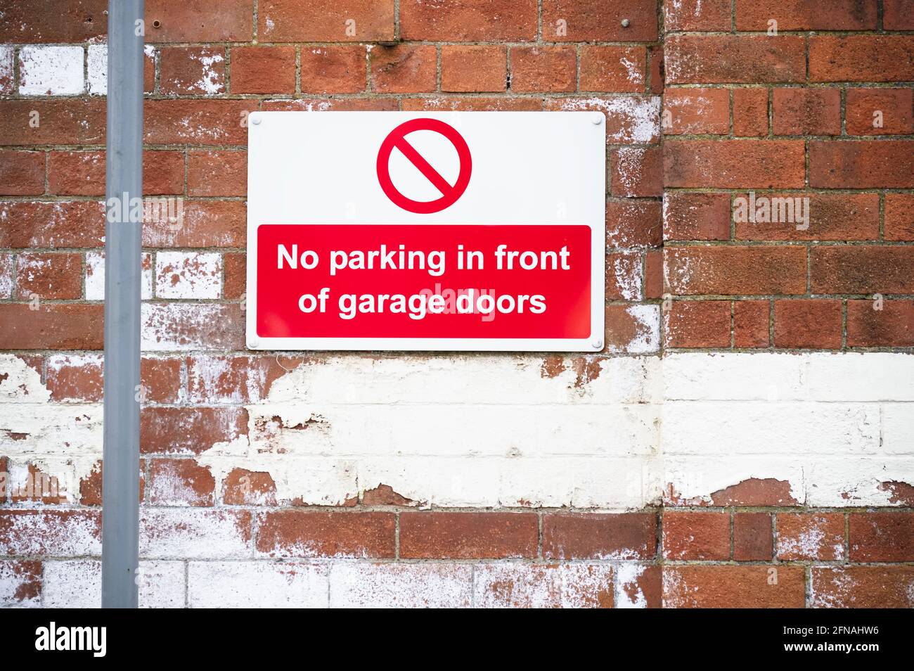 No parking in front of garage doors red sign Stock Photo Alamy