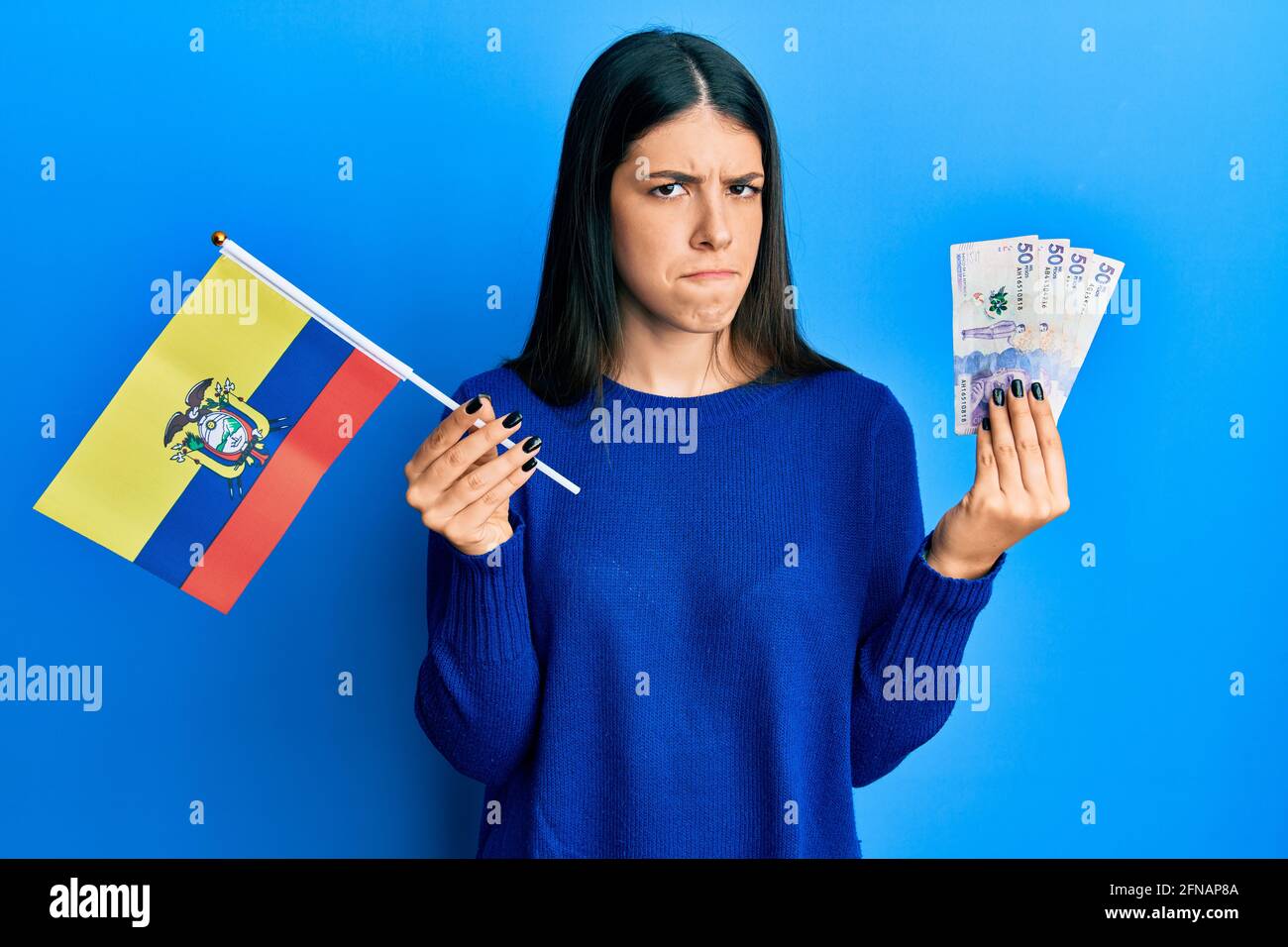 Young hispanic woman holding colombia flag and colombian pesos ...