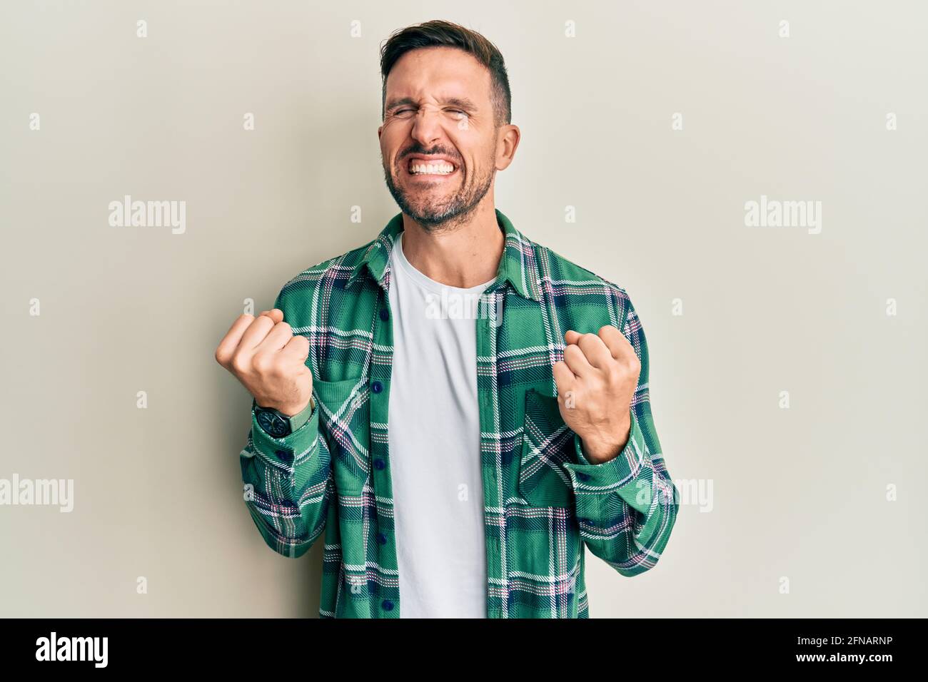Handsome man with beard wearing casual clothes very happy and excited ...