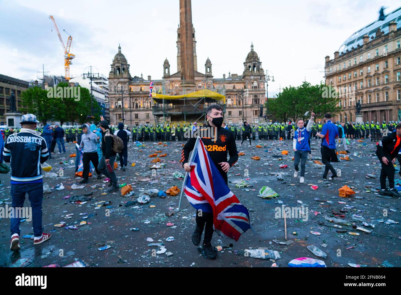 Glasgow, Scotland, UK. 15 May 202. Rangers football supporters  celebrating 55th league victory are cleared from George Square by police in riot gear on Saturday evening. In very violent scenes police were pelted with bottles and items from a nearby construction site as police pushed the supporters into the south west corner of the square.  Iain Masterton/Alamy Live News. Stock Photo