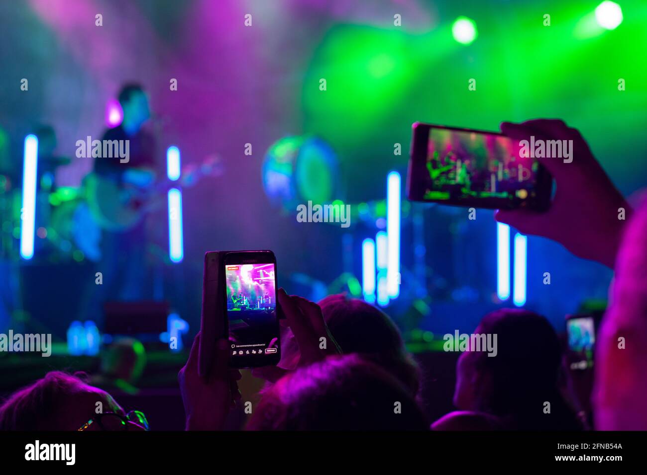 Public recording and using smartphones on live music festivals, handling smartphones to record live performances. Music festivals light colors and crowd Stock Photo