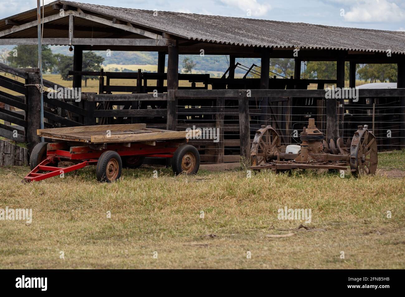Wooden corral for handling livestock on farm with tractor equipment