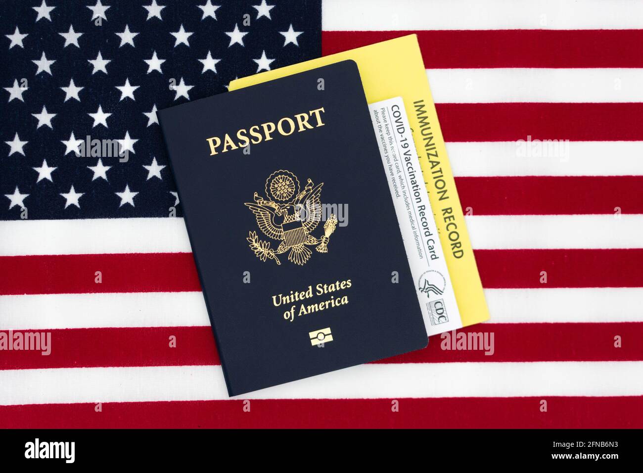 COVID-19 vaccination official CDC record card, immunization card and US Passport book on the Flag of the United States - San Jose, California, USA - 2 Stock Photo