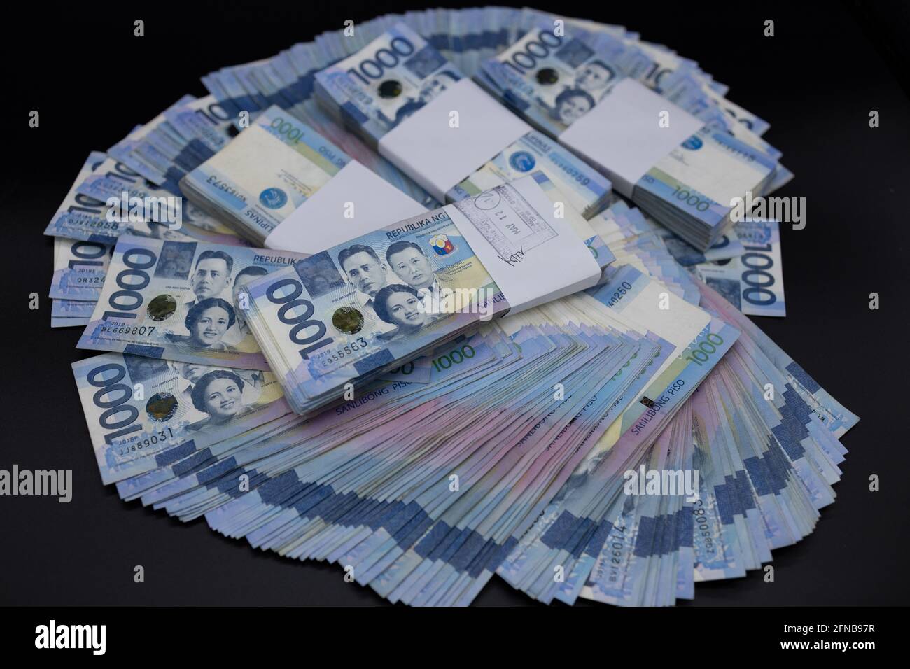 A pile of one thousand Philippines banknotes. Cash of Thousand dollar bills, Peso background image. Stock Photo