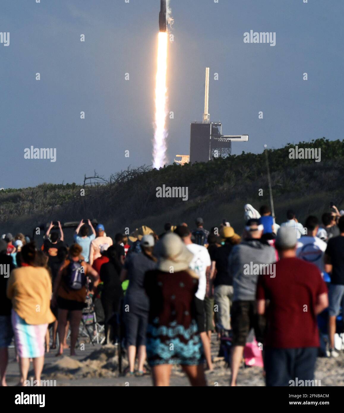Cape Canaveral, United States. 15th May, 2021. People watch from Playalinda Beach at Canaveral National Seashore as a SpaceX Falcon 9 rocket carrying the 28th batch of satellites for SpaceXs Starlink broadband network launches from pad 39A at the Kennedy Space Center. In addition to 52 Starlink satellites, the rocket is also carrying rideshare payloads for Capella Space and Tyvak Nano-Satellite Systems. Credit: SOPA Images Limited/Alamy Live News Stock Photo