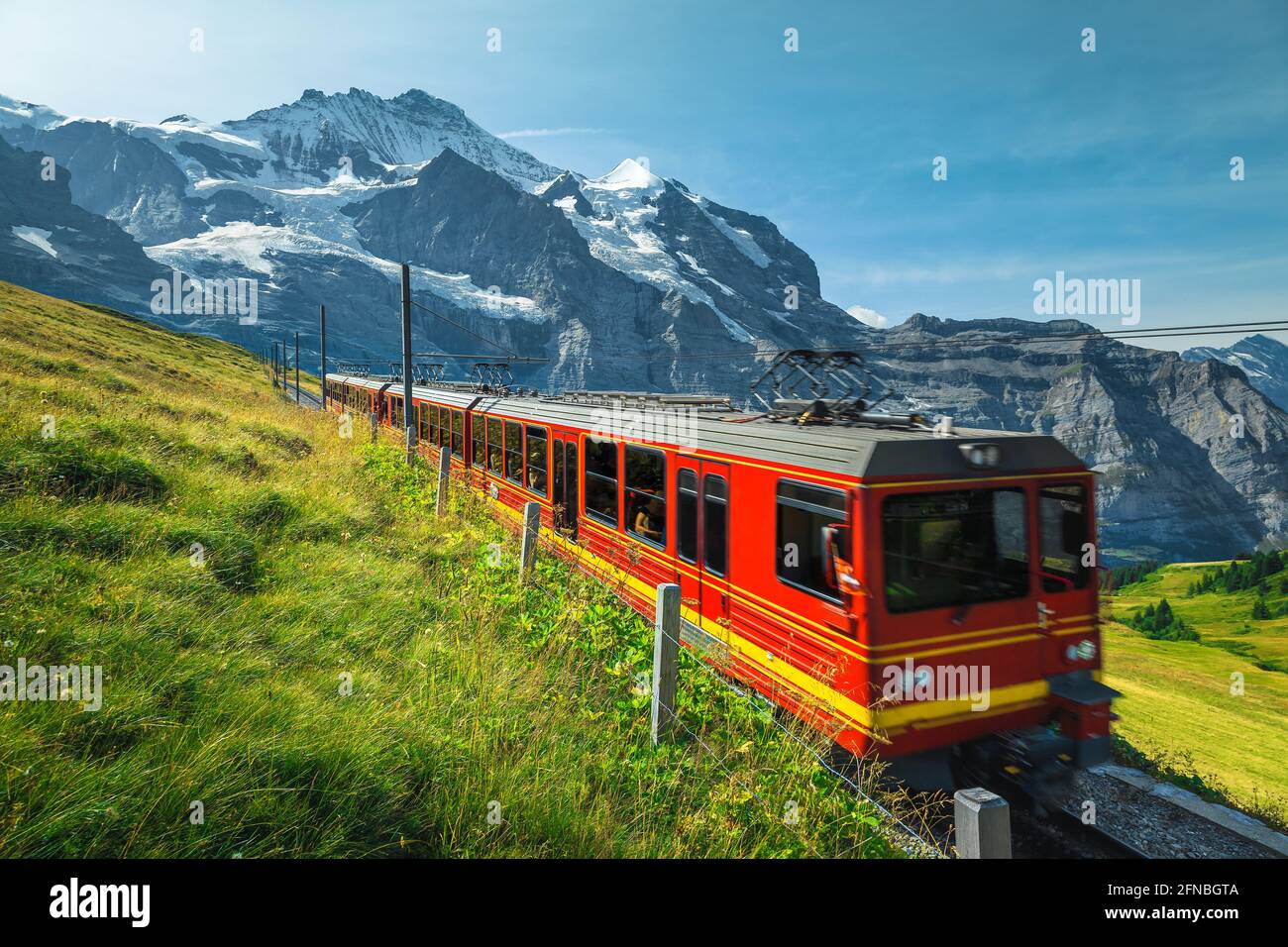 Mountain railroad with modern cogwheel red tourist train on the slope ...