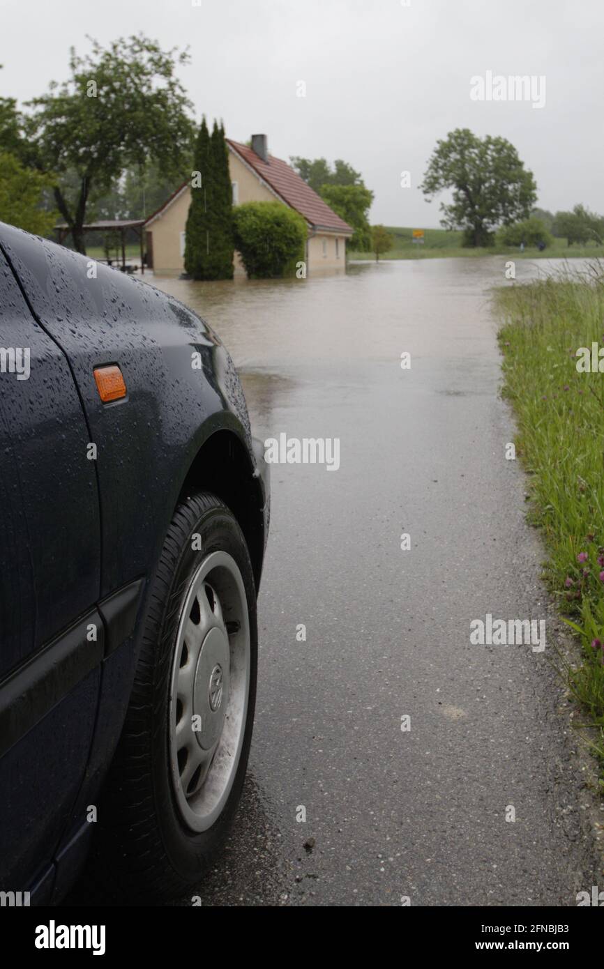 Überflutung auf der Landstrasse - Ein Auto steht an einer überschwemmten Straße Stock Photo