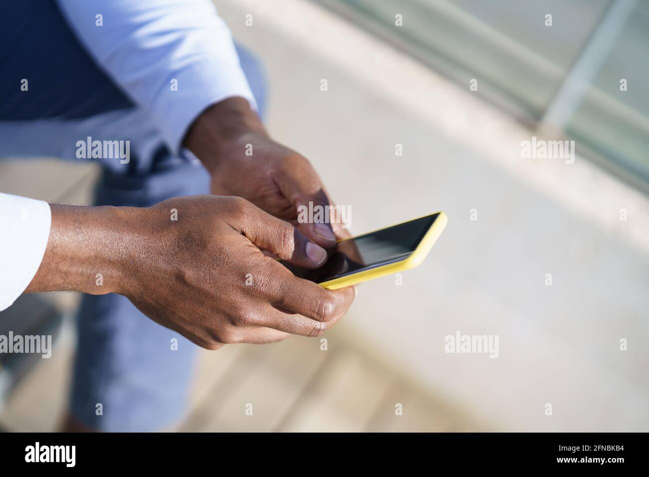 Hands of unrecognizable black man using a smartphone. Stock Photo