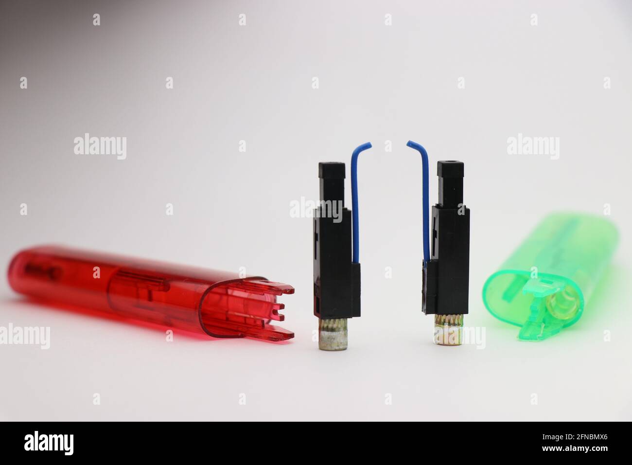 Dismantled fire lighters with close-up of Piezo ignition device on white background Stock Photo