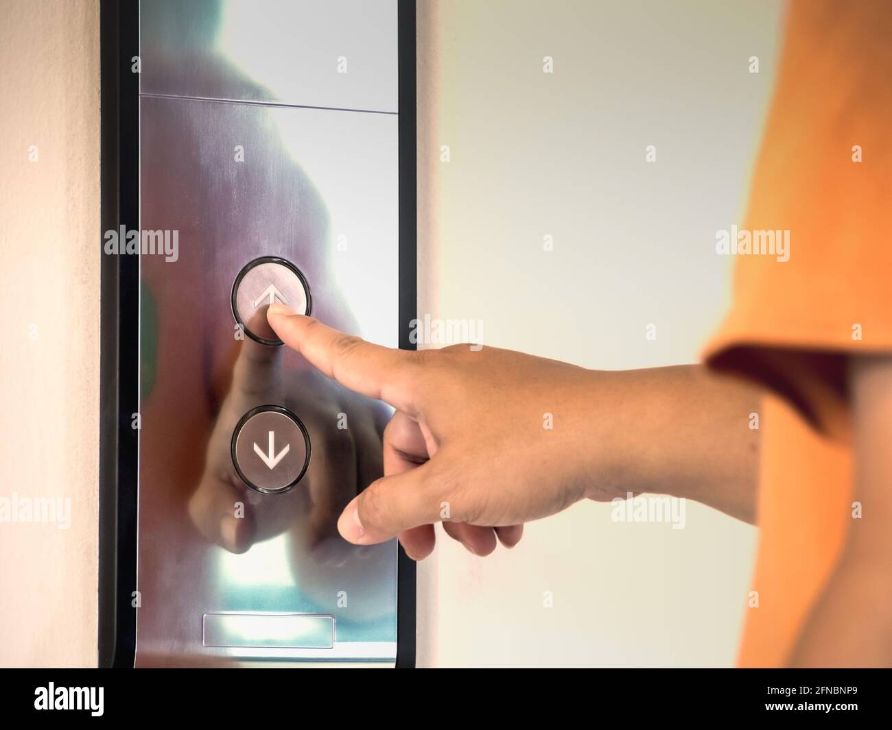 The finger of male pressing the elevator or lift button for next level up in apartment or condominium. More advance to success concept. Stock Photo