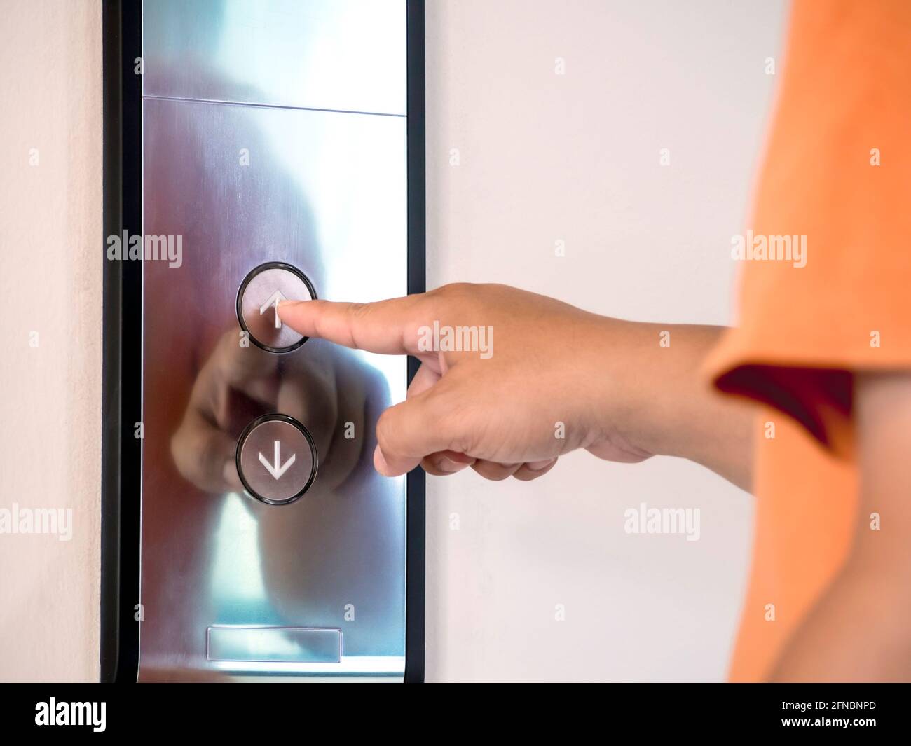The finger of male pressing the elevator or lift button for next level up in apartment or condominium. More advance to success concept. Stock Photo