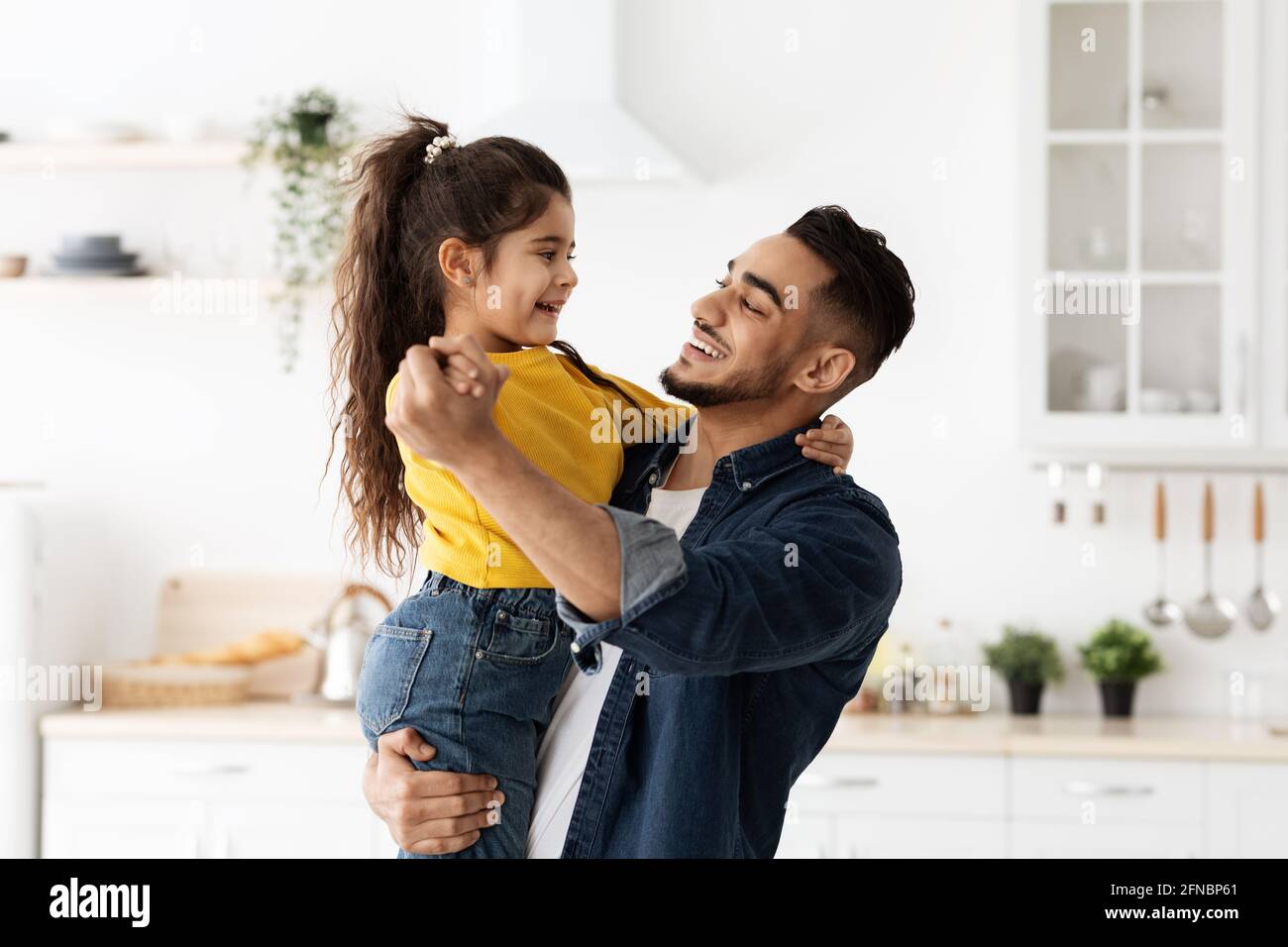 Portrait Of Cheerful Arab Dad Dancing With His Little Daughter At Home Stock Photo