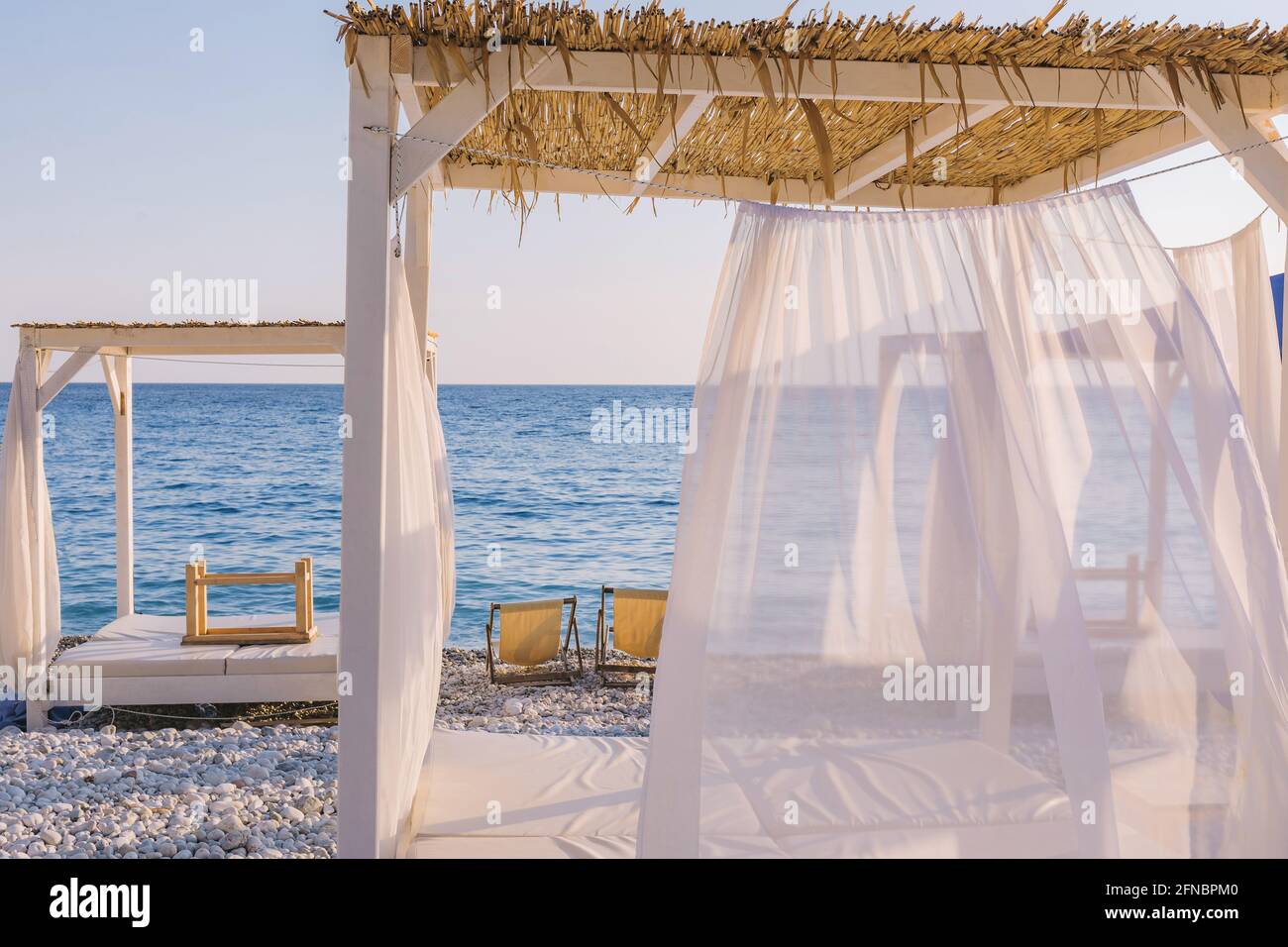 Beautiful canopies or baldachine at sea beach at the sunset. Vacation and relaxation concept. Stock Photo