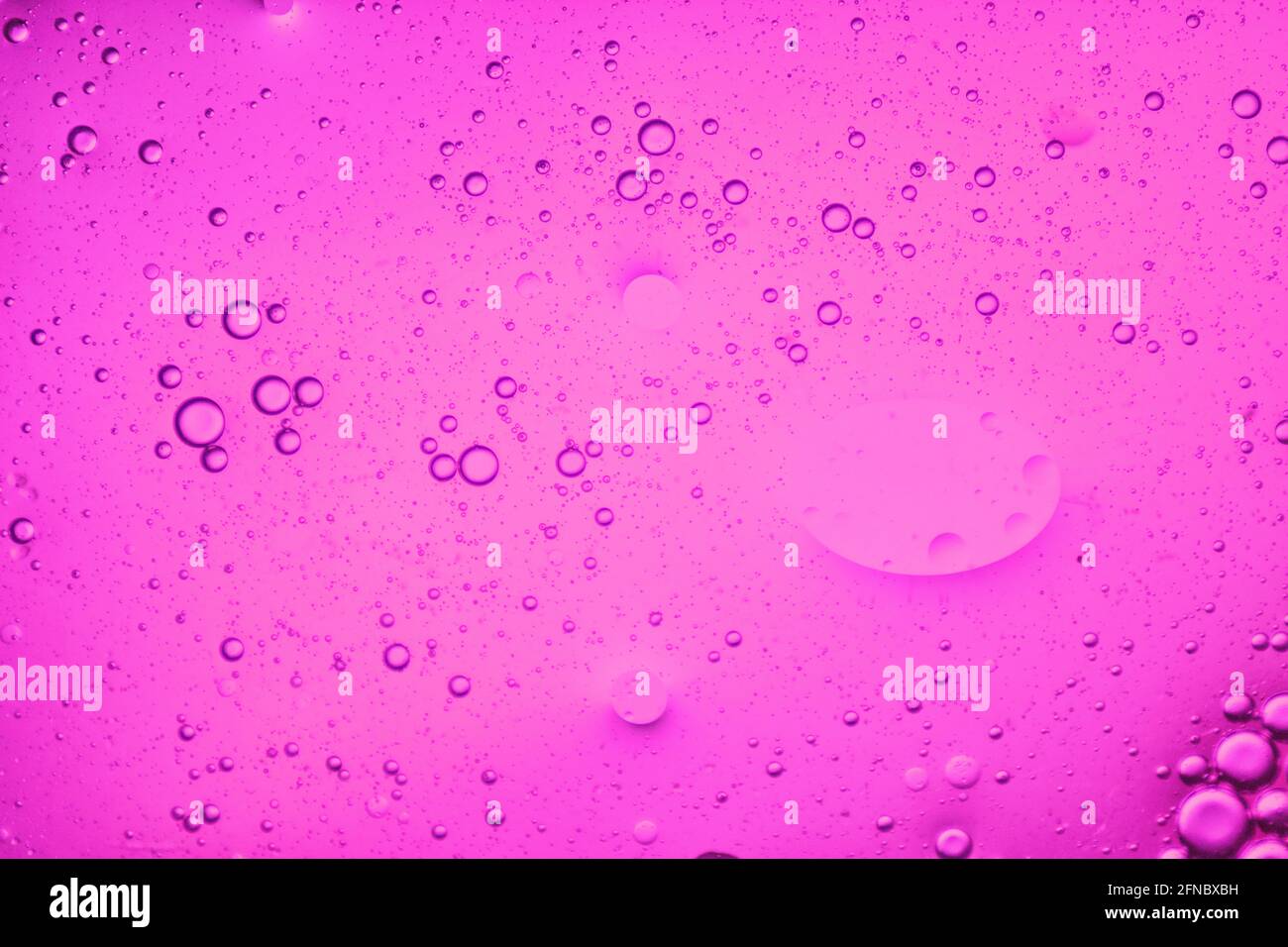 close-up view of a soft pink liquid background of moving bubbles Stock Photo