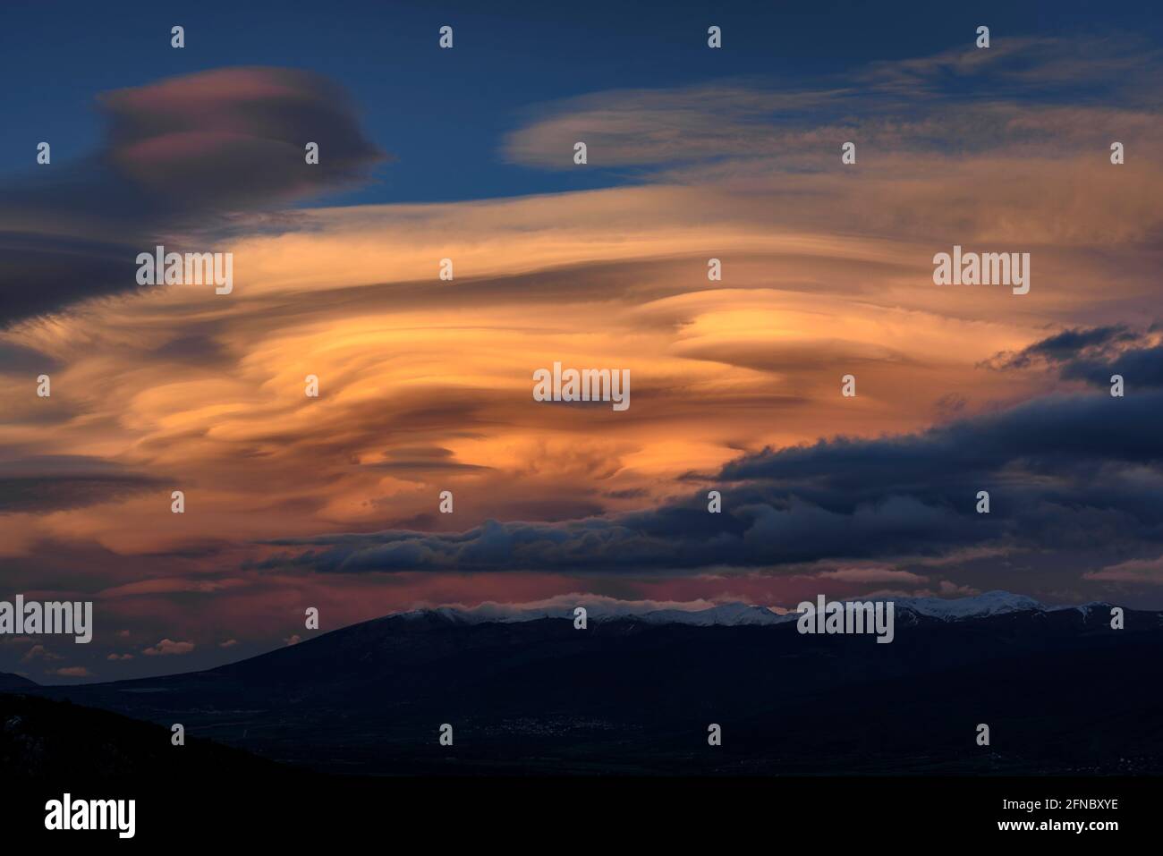 Spring sunset in La Cerdanya, seen from near Ordèn, with lenticular clouds over Puigmal - Cambredase (Lleida, Catalonia, Spain, Pyrenees) Stock Photo