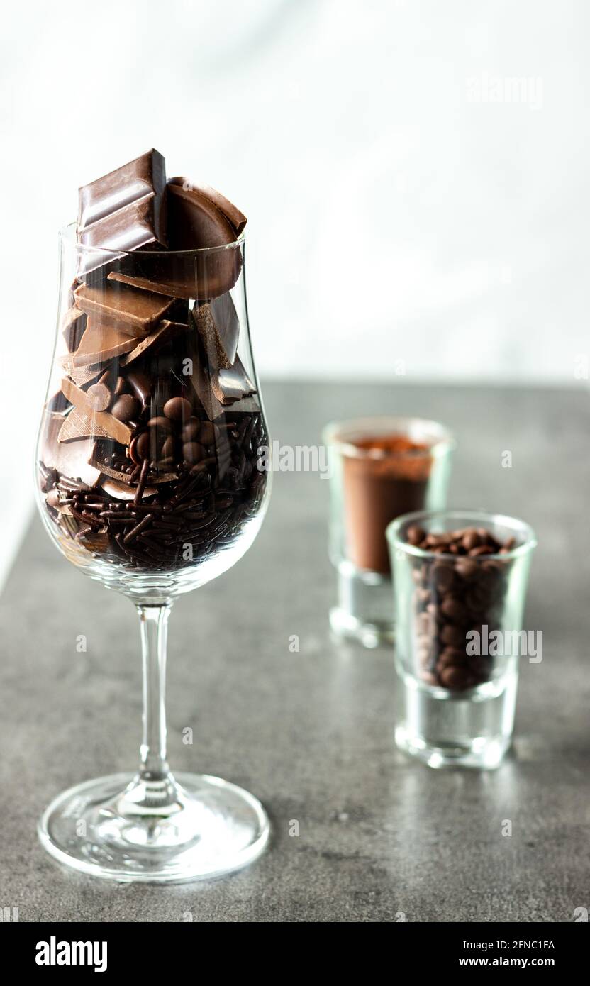 Wine glass filled with different kinds of chocolates; sweet craving; chocolate snack Stock Photo