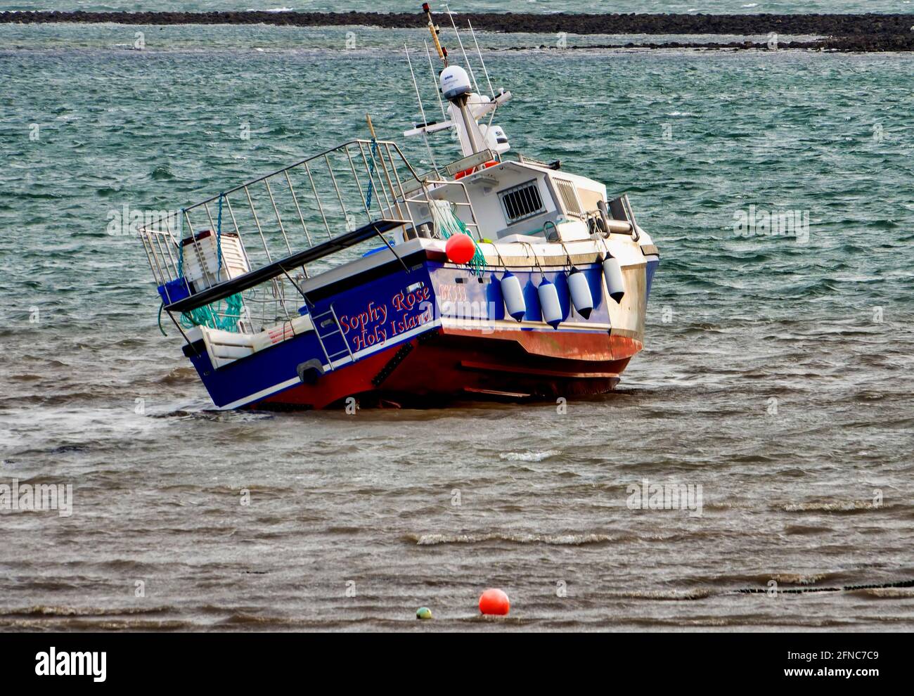 Fishing boat in the harbor as the tide comes in. Stock Photo