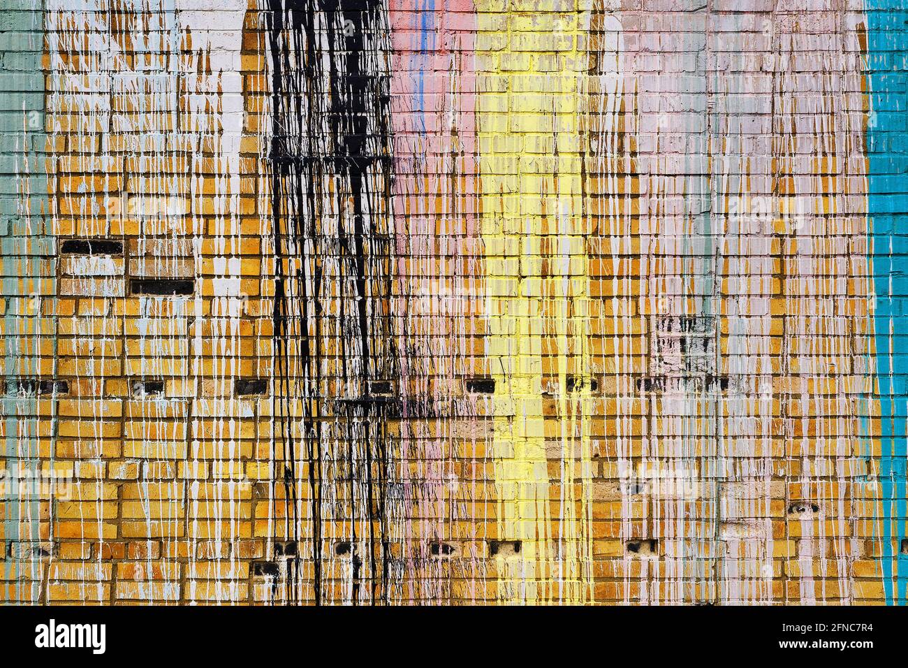 Brick wall with multi-colored drips of paint. Stock Photo