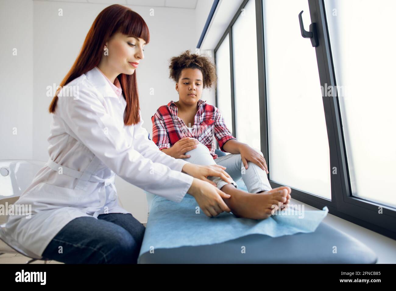 Trauma on the child's leg. Female Caucasian doctor orthopedist