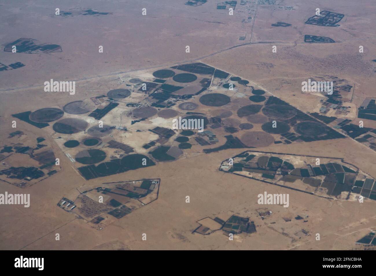 Doha – Qatar, May 12, 2021: Aerial view showing circular irrigation patterns of farms surrounded by desert Stock Photo