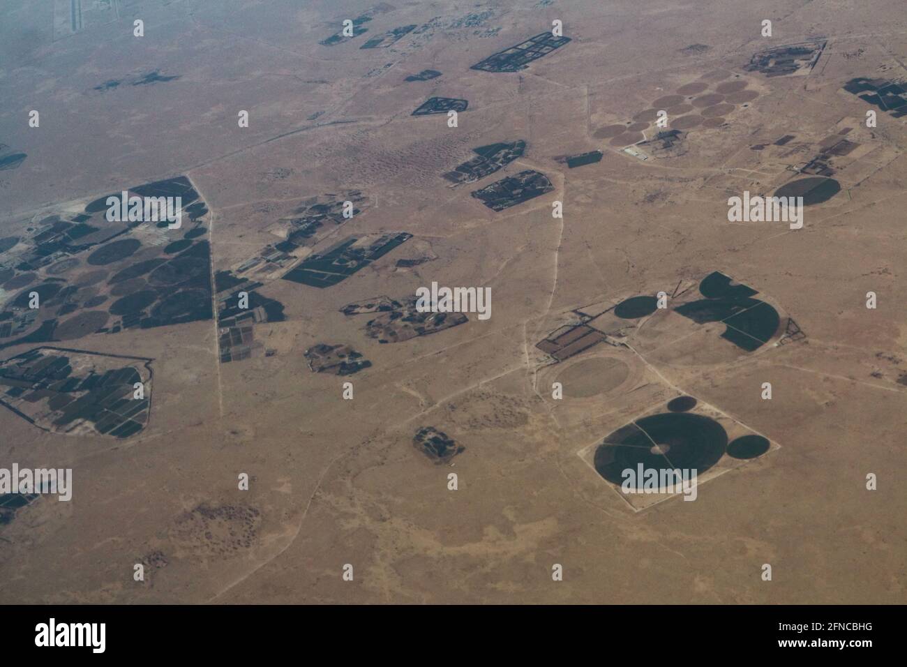 Doha – Qatar, May 12, 2021: Aerial view showing circular irrigation patterns of farms surrounded by desert Stock Photo