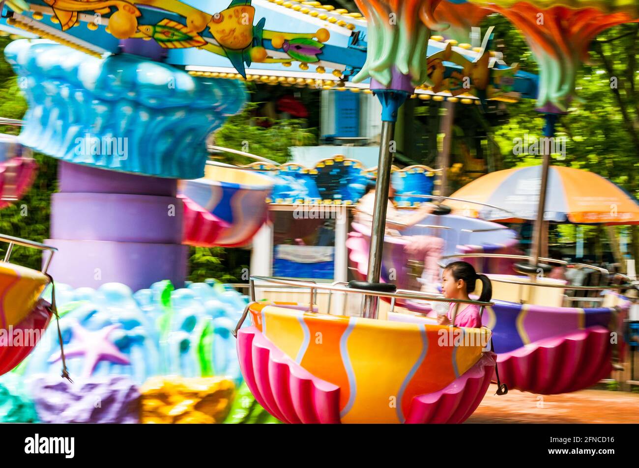 A child enjoys a colorful amusement ride in Shanghai’s Zhongshan Park ...