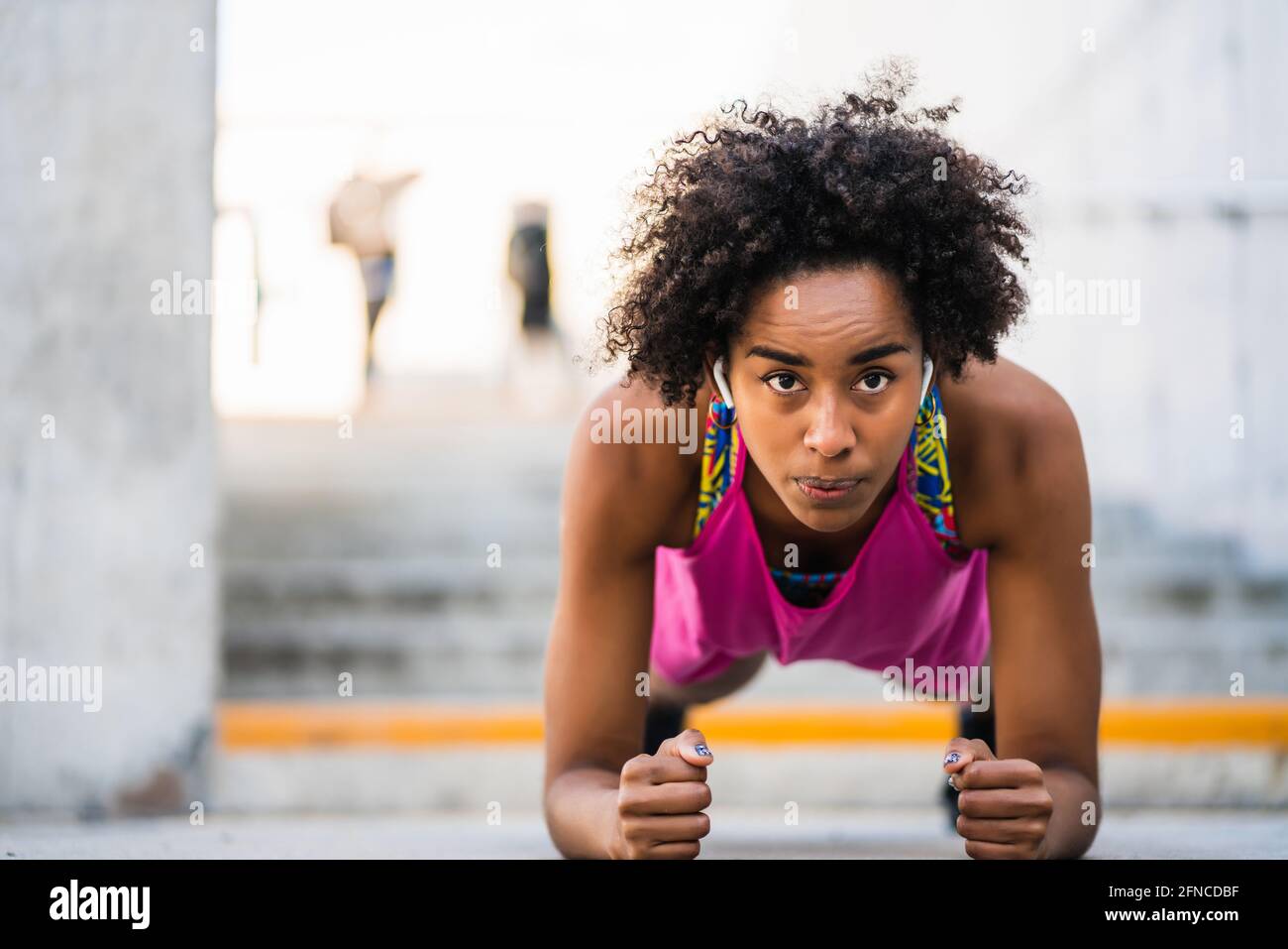 Afro athlete woman doing pushups outdoors. Stock Photo