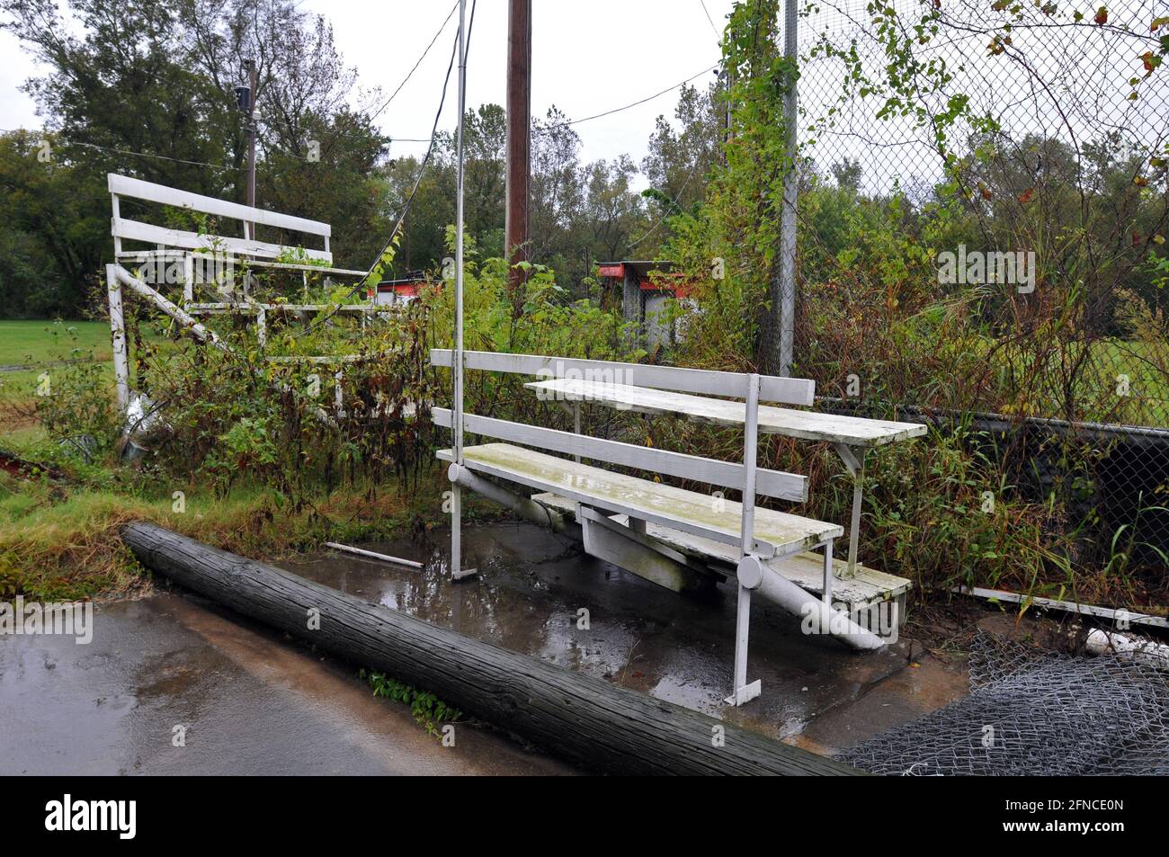 Empty bleachers stand at an overgrown baseball field in the Route 66
