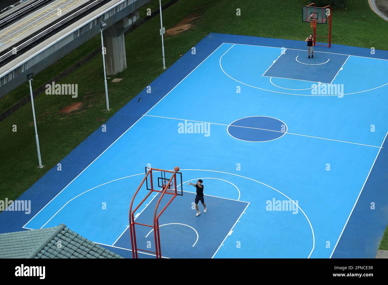 Singapore, Singapore. 16th May, 2021. People play basketball as sports such as basketball can only take place in a group of not more than two people at Choa Chu Kang in Singapore.Tightened COVID-19 measures known as Phase 2 (Heightened Alert) starts from May 16 to Jun 13, 2021 with groups sizes reduced from 5 to 2 and no dining-in allowed. Credit: SOPA Images Limited/Alamy Live News Stock Photo