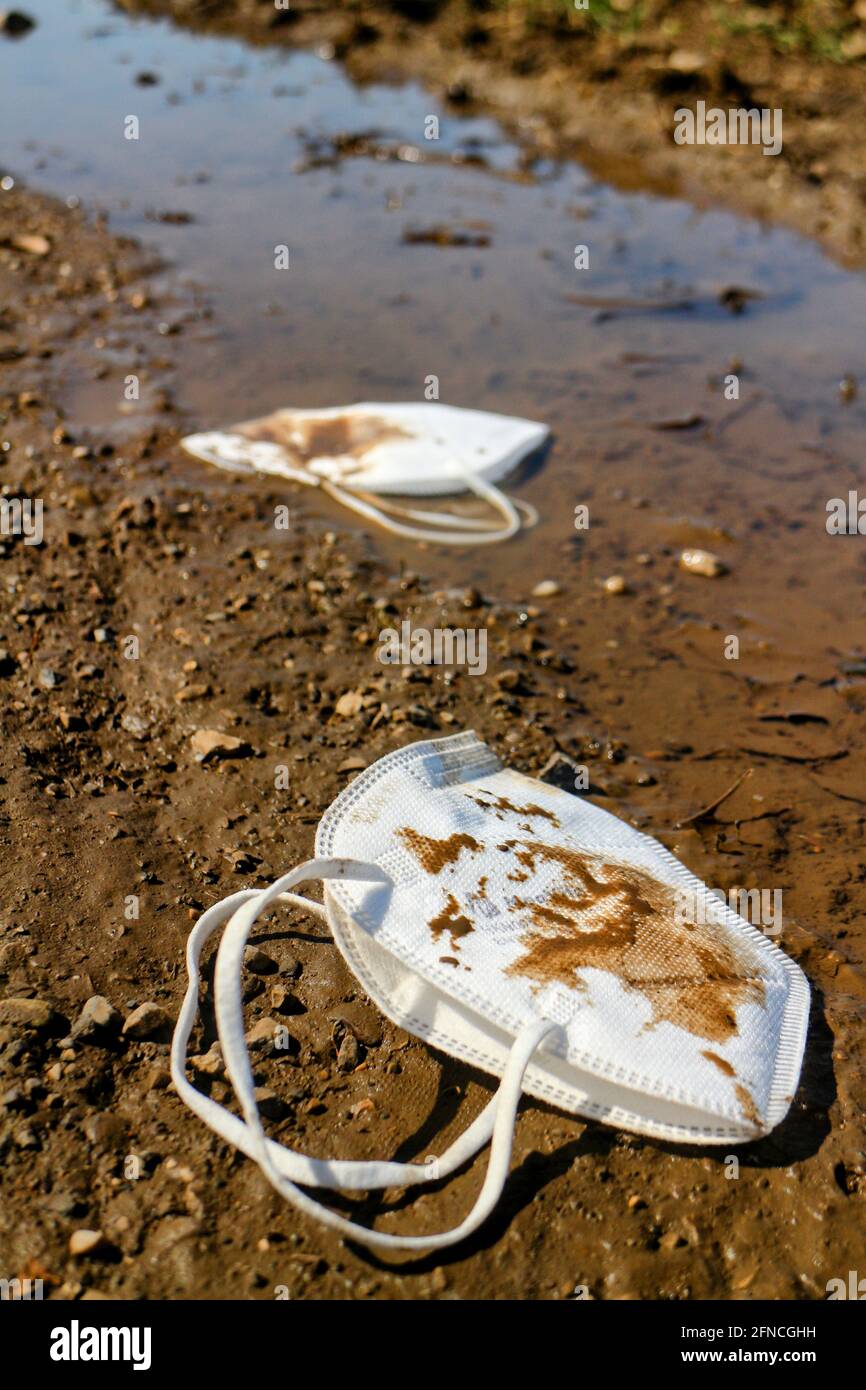 Masks lying in the dirt on the street Stock Photo