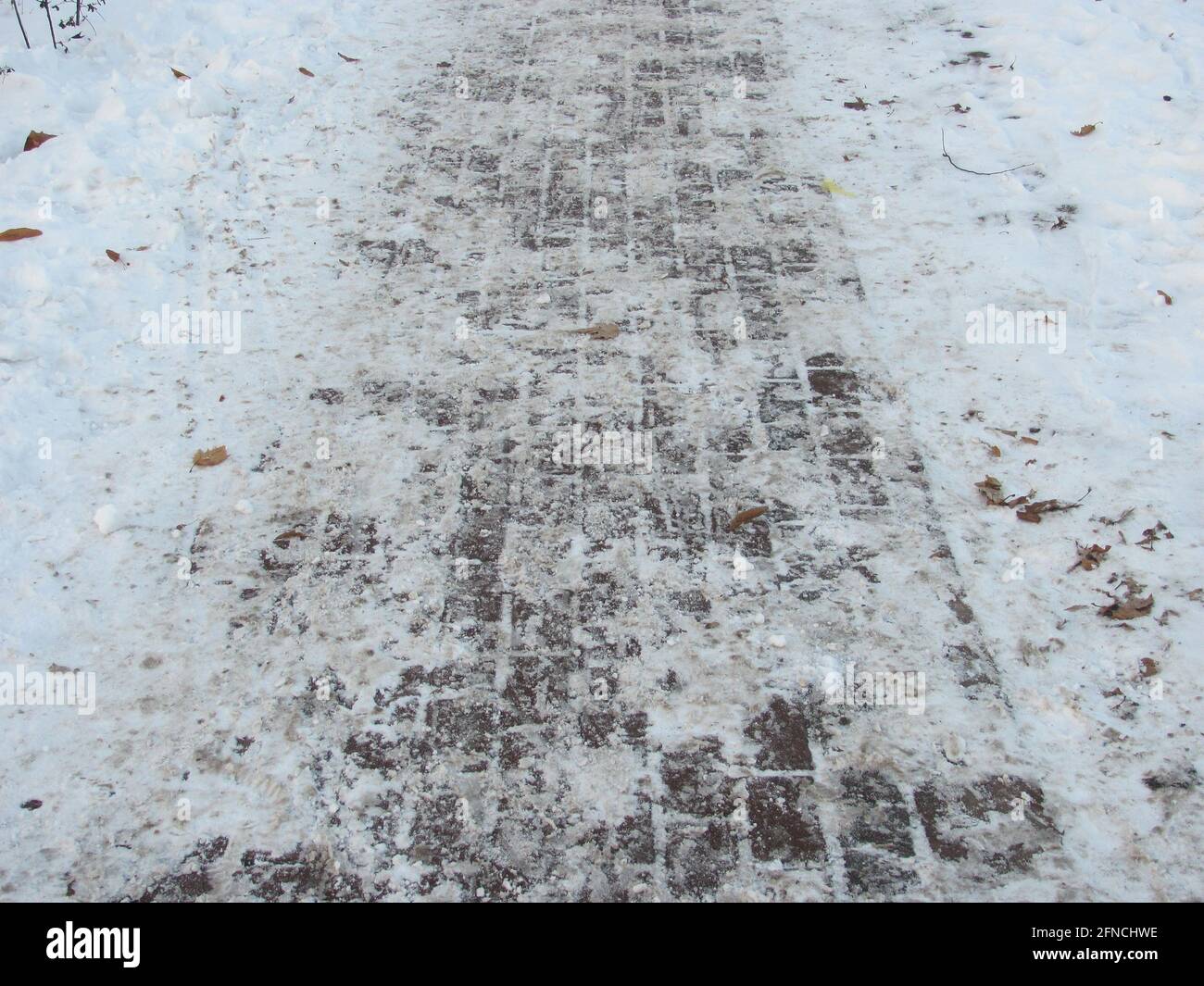A tiled path in a snow-covered park Stock Photo