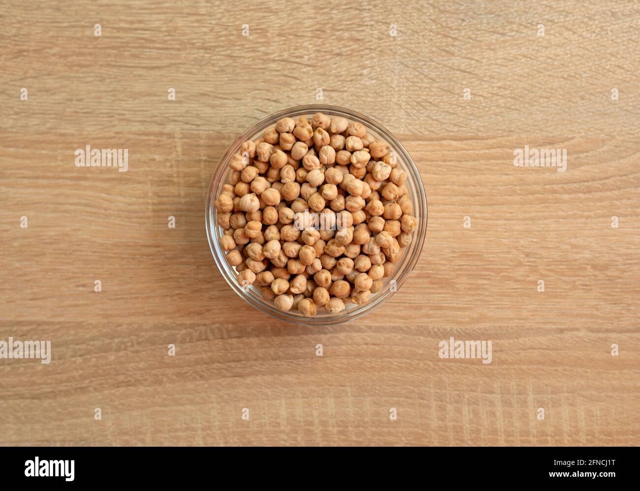Bowl of raw grain chickpeas on a wooden table Stock Photo