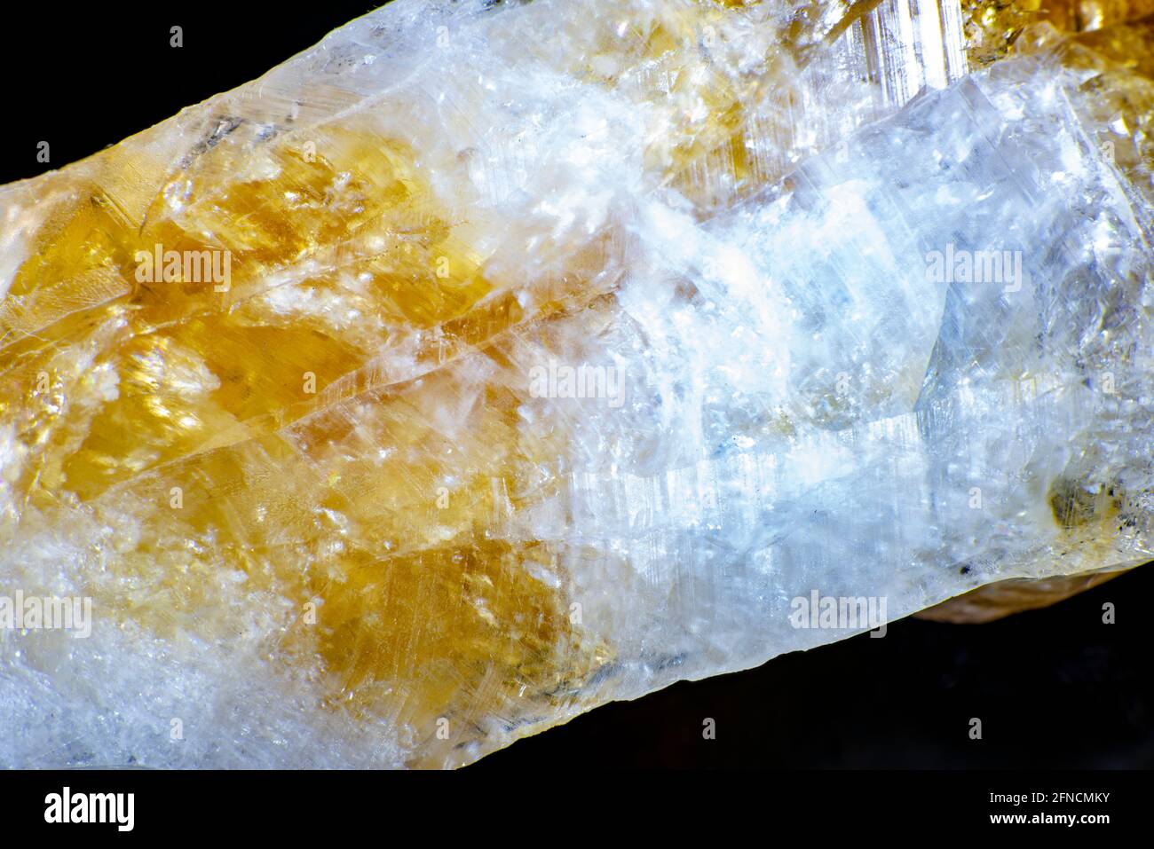 macro shooting of natural rock specimen. Raw crystal of Citrine yellow quartz gemstone from Brazil. Shimmering gold background. High quality photo Stock Photo