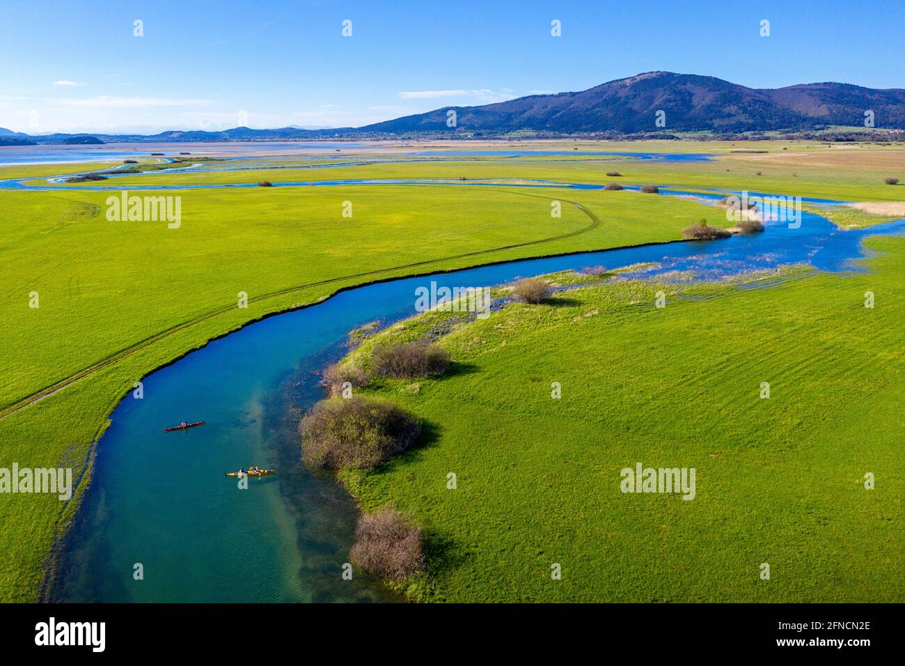 Top aerial view of two kayaks in tributary that flows into Cerknica Lake, beautiful view over the lake and mountains, taken by drone, Slovenia Stock Photo