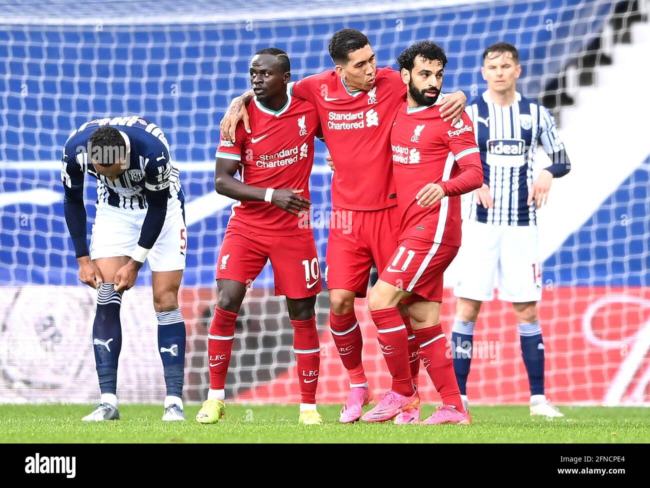 Liverpool's Mohamed Salah (right) celebrates scoring their side's first goal of the game with team-mates Sadio Mane and Roberto Firmino during the Premier League match at The Hawthorns, West Bromwich. Picture date: Sunday May 16, 2021. Stock Photo