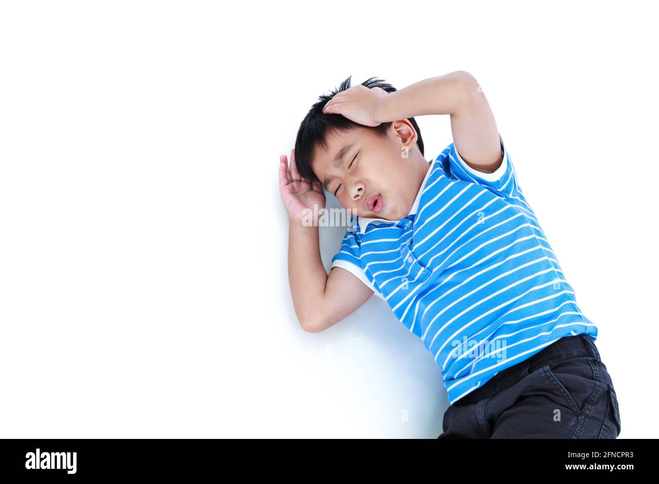 Top view child lie down. Asian boy have a headache, his hand on head, emotion feeling sign. Isolated on white background. Negative human emotion, faci Stock Photo