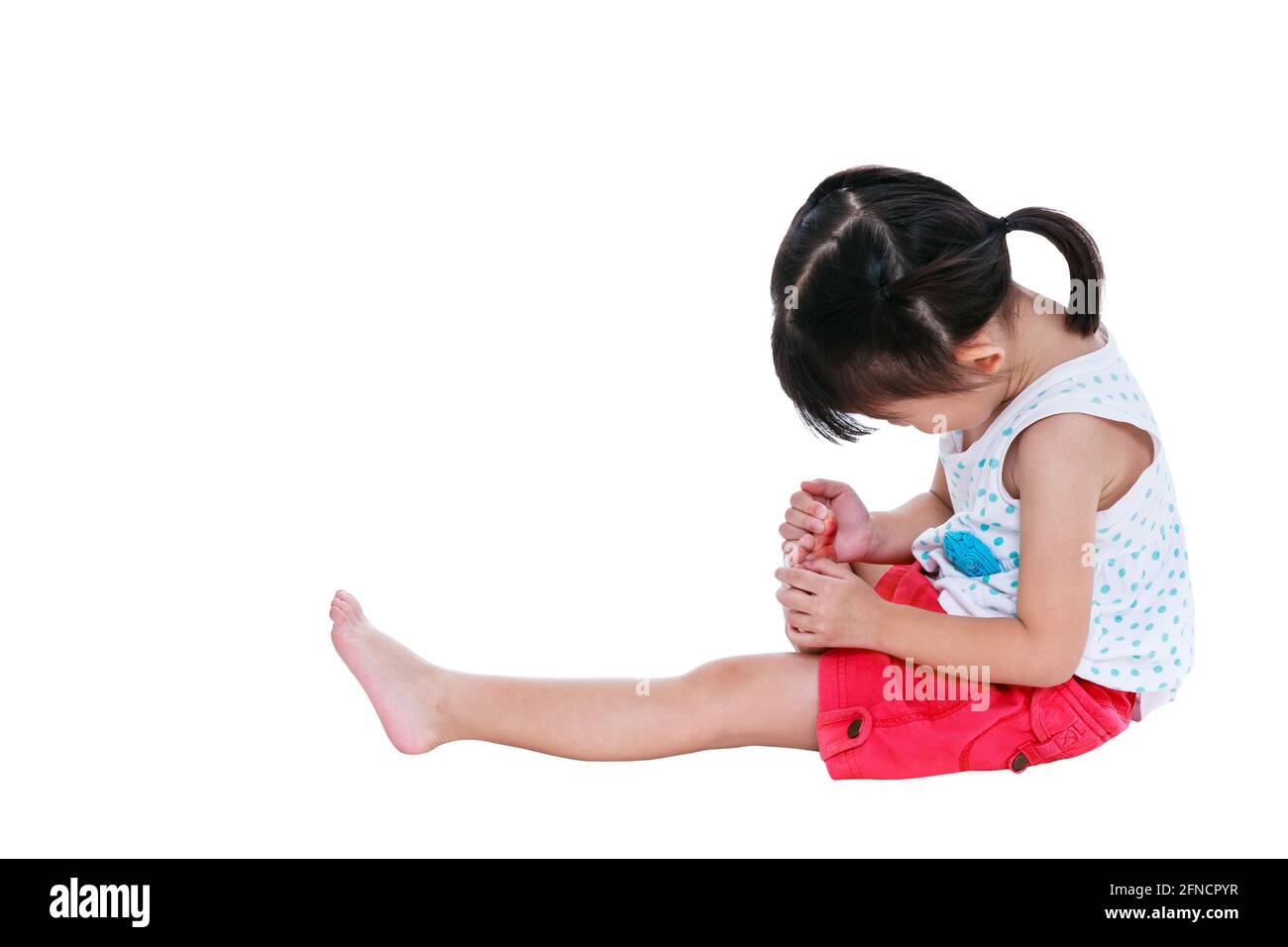 Full body of sad japanese child in pink skirt injured at toenail. Isolated on white background with copy space. Studio shot. Human healthcare and prob Stock Photo