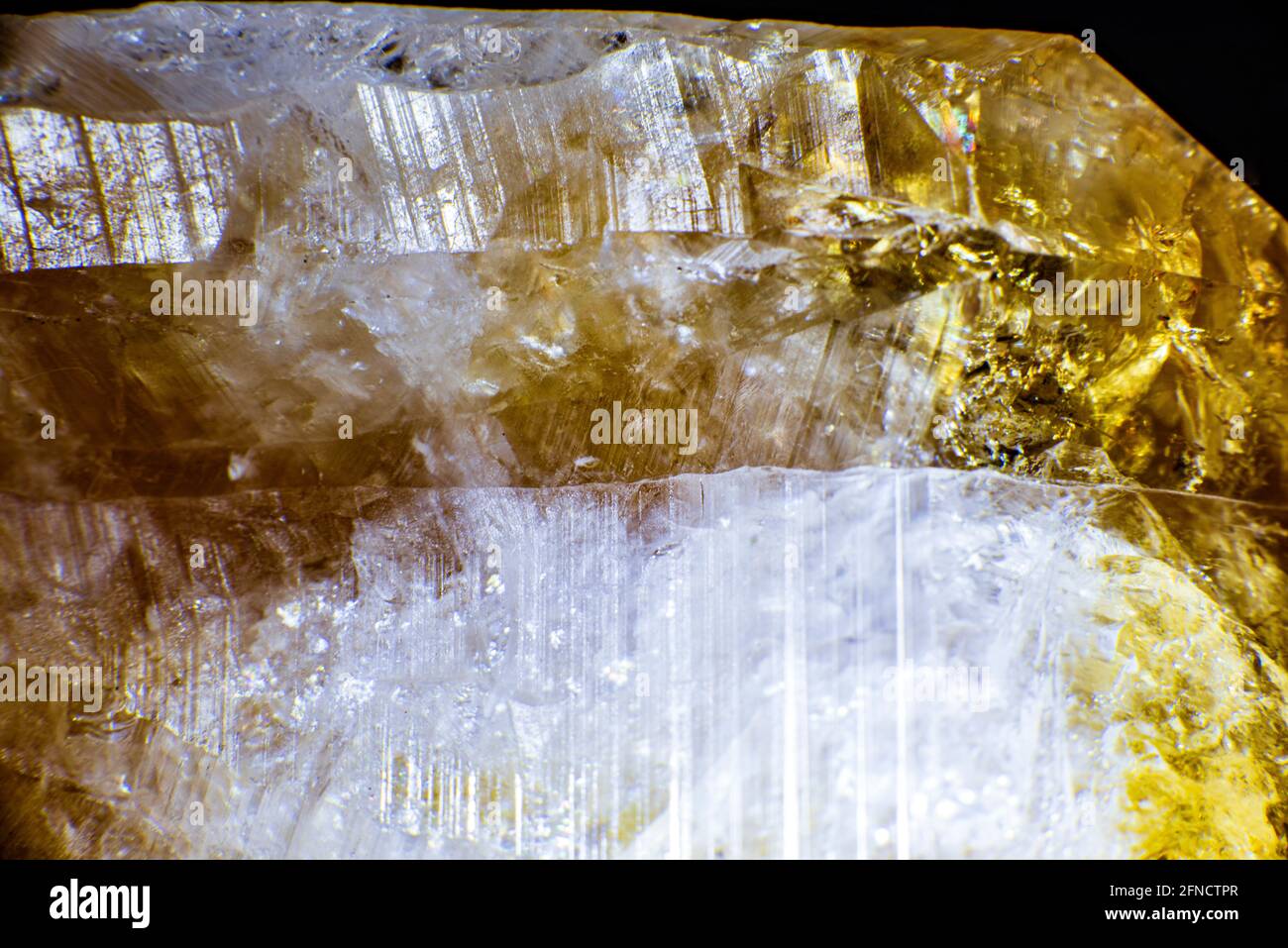 macro shooting of natural rock specimen. Raw crystal of Citrine yellow quartz gemstone from Brazil. Shimmering gold background. High quality photo Stock Photo