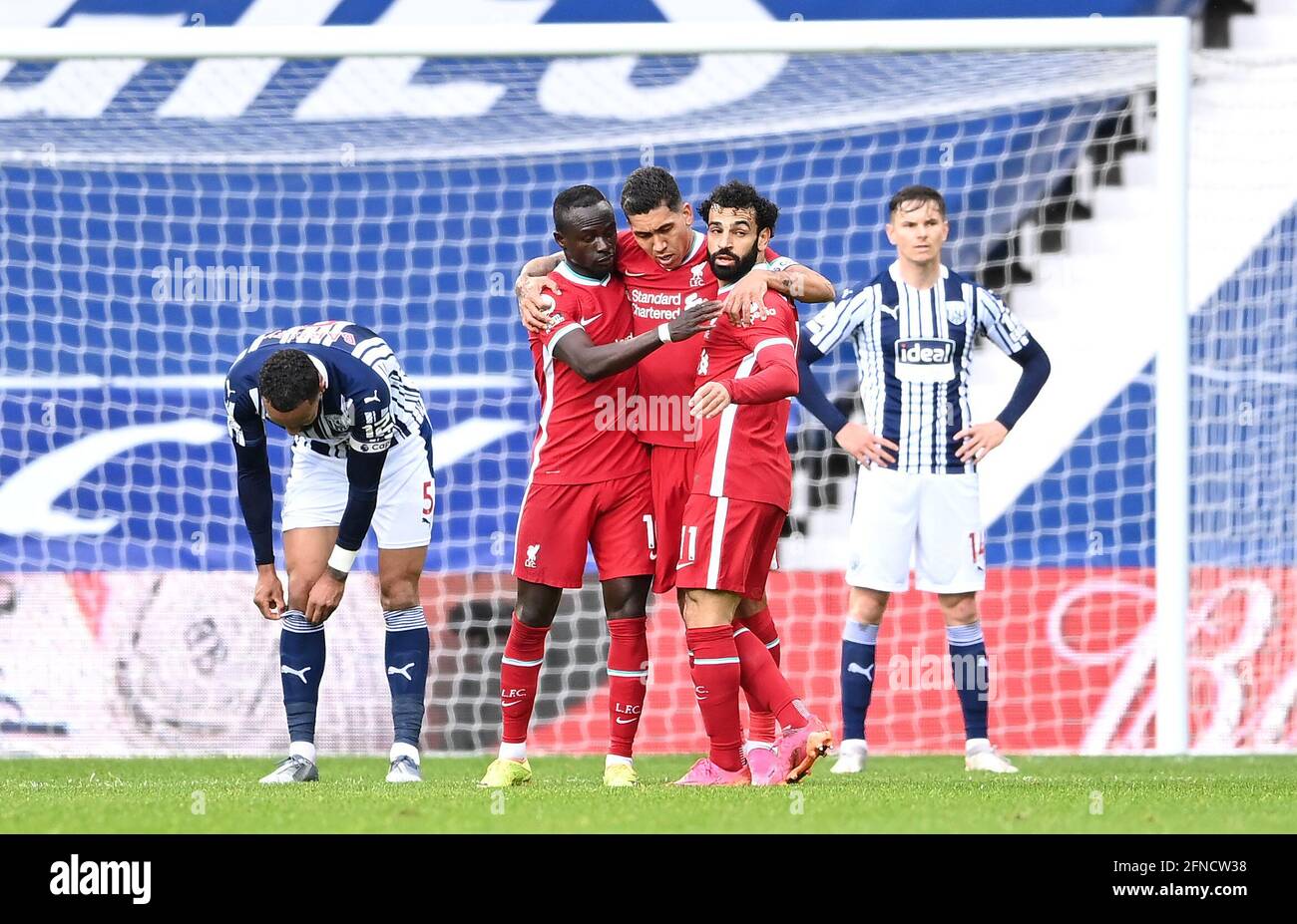 Liverpool's Mohamed Salah (right) celebrates scoring their side's first goal of the game with team-mates Sadio Mane and Roberto Firmino during the Premier League match at The Hawthorns, West Bromwich. Picture date: Sunday May 16, 2021. Stock Photo