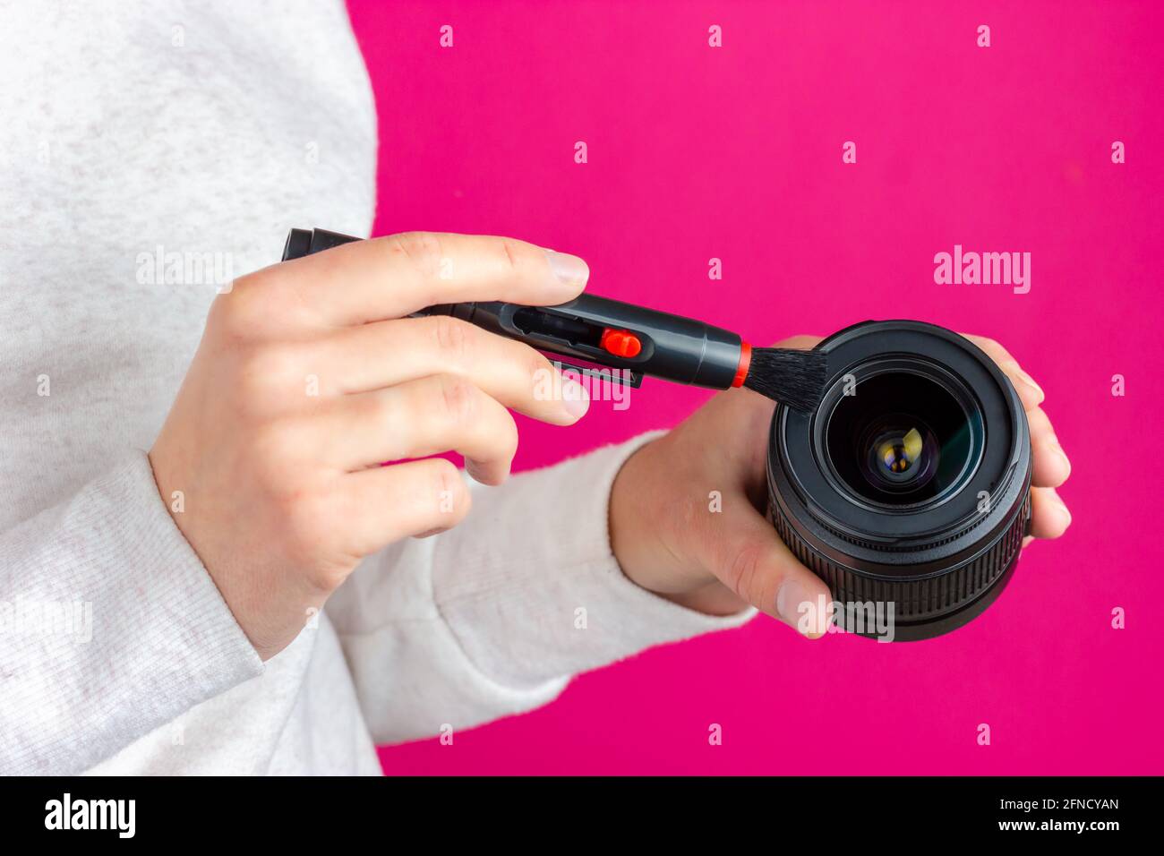 Photo lens cleaning process. The photographer is cleaning his lens